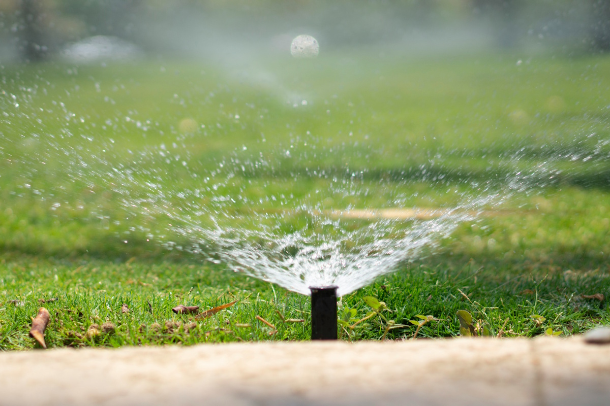 Aspersor de riego automático funcionando en jardín de Cambrils